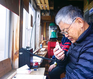 写真：無線ネットワークで連絡する五十嶋さん